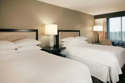 two beds in a hotel room with white pillows at Sheraton Bucks County Langhorne in Langhorne