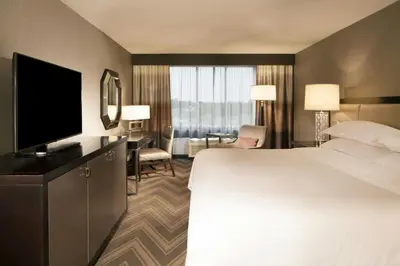 a hotel room with a bed and a flat screen tv at Sheraton Bucks County Langhorne in Langhorne