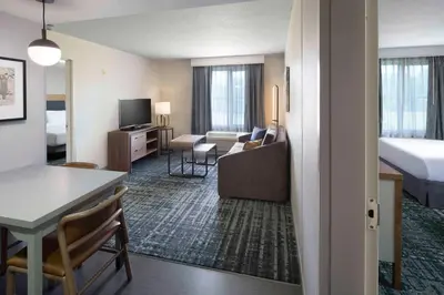 a hotel room with a bed and a living room at Homewood Suites by Hilton Newburgh-Stewart Airport in New Windsor