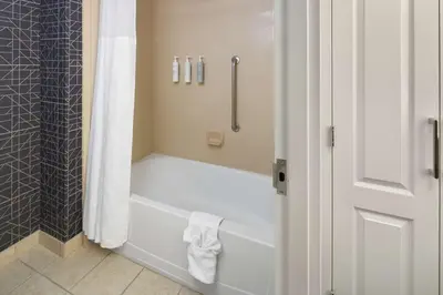 a bathroom with a white tub and a shower at Homewood Suites by Hilton Newburgh-Stewart Airport in New Windsor