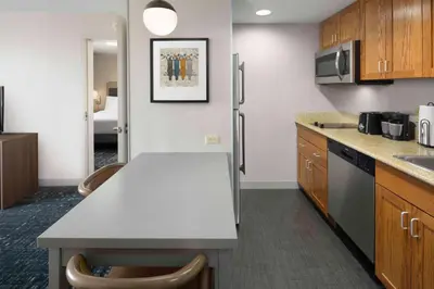 a kitchen with a counter and a refrigerator at Homewood Suites by Hilton Newburgh-Stewart Airport in New Windsor