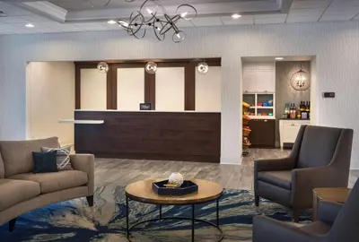 a lobby with a waiting room with chairs and a table at Homewood Suites by Hilton Newburgh-Stewart Airport in New Windsor