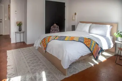 a bedroom with a large bed with white sheets at Billy Penn Studio at Kestrel Hotel in Philadelphia