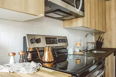 a kitchen with a stove and a sink at Billy Penn Studio at Kestrel Hotel in Philadelphia