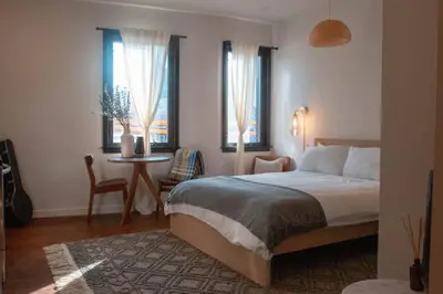 a bedroom with a bed and a table and windows at Poor Richard Studio at Kestrel Hotel in Philadelphia