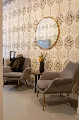 a room with two chairs and a mirror on a wall at Poor Richard Studio at Kestrel Hotel in Philadelphia