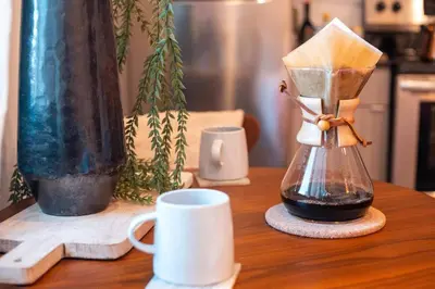 a coffee maker sitting on a table with a coffee cup at Poor Richard Studio at Kestrel Hotel in Philadelphia