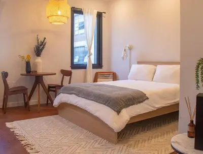 a bedroom with a bed and a table and a window at Rail Park Studio at Kestrel Hotel in Philadelphia