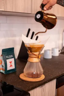 a person pouring a drink into a blender on a counter at Rail Park Studio at Kestrel Hotel in Philadelphia