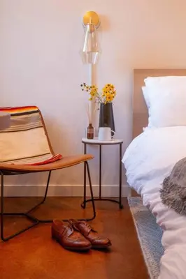 a bedroom with a chair and a bed and a table at Rail Park Studio at Kestrel Hotel in Philadelphia