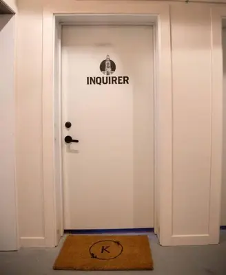 a white door with a sign on it and a rug at Inquirer Studio at Kestrel Hotel in Philadelphia