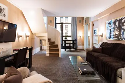 a living room with a couch and a tv at City Club Hotel in New York