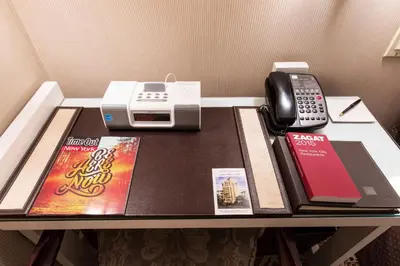 a table with a phone and a book on it at City Club Hotel in New York
