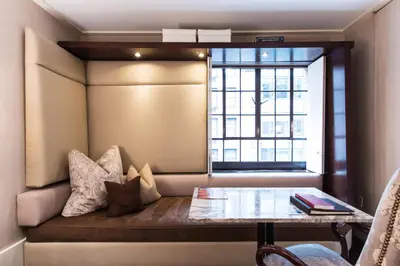 a room with a window seat with a table and pillows at City Club Hotel in New York