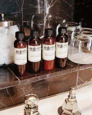 four bottles of spices sitting on a bathroom sink at City Club Hotel in New York