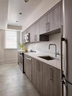 a kitchen with wooden cabinets and a sink at AKA Rittenhouse Square in Philadelphia