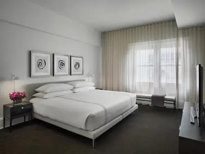 a white bedroom with a large bed and a window at AKA Rittenhouse Square in Philadelphia