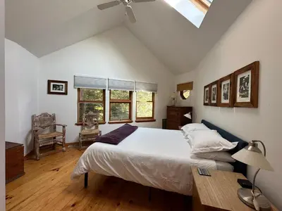 a bedroom with a bed and a desk and a window at A River Runs Through It in East Branch