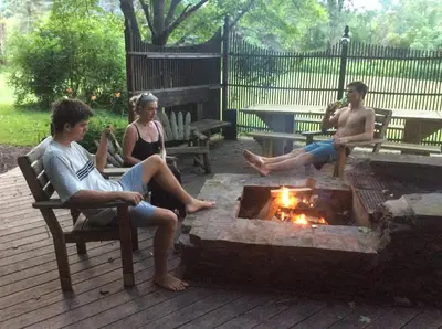 a group of people sitting around a fire pit at A River Runs Through It in East Branch