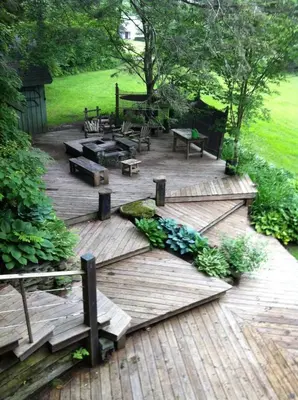 a wooden deck with benches and a picnic table at A River Runs Through It in East Branch