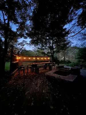 a picnic table with lights in a park at night at A River Runs Through It in East Branch