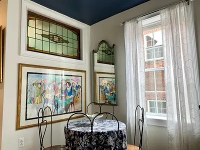 a dining room with a table and two windows at The Philadelphia Hotel Bella Vista in Philadelphia