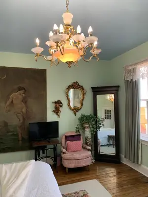 a bedroom with a chandelier and a chair and a mirror at The Philadelphia Hotel Bella Vista in Philadelphia