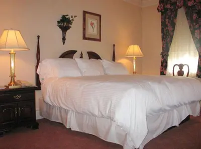 a bedroom with a large white bed with two lamps at Bird-in-Hand Village Inn & Suites in Bird in Hand
