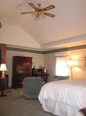 a bedroom with a bed and a ceiling fan at Bird-in-Hand Village Inn & Suites in Bird in Hand