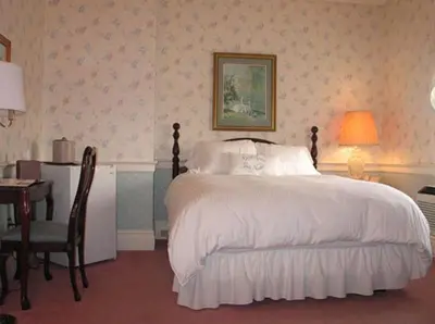 a bedroom with a bed and a desk with a desk at Bird-in-Hand Village Inn & Suites in Bird in Hand