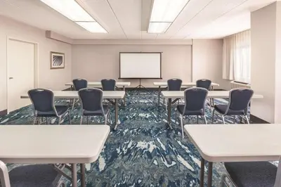 a conference room with tables and chairs and a whiteboard at La Quinta by Wyndham Philadelphia Airport in Essington