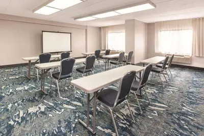 a classroom with tables and chairs and a whiteboard at La Quinta by Wyndham Philadelphia Airport in Essington