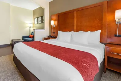 a hotel room with a large bed with a red blanket at Comfort Suites Newark - Harrison in Newark