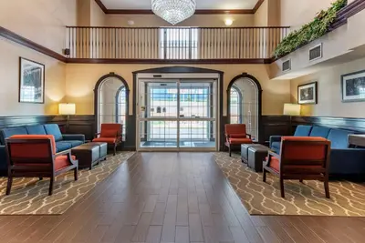 a waiting room at a hospital with chairs and tables at Comfort Suites Newark - Harrison in Newark