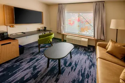 a hotel room with a couch and a chair at Fairfield Inn & Suites Scranton Montage Mountain in Moosic