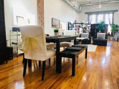 a table and chairs in a living room at UPDATED Amazing Bi -Level Condo minutes from water views of New York City in North Bergen