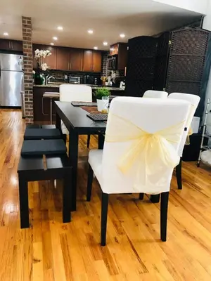 a dining room with a white chair with a bow on it at UPDATED Amazing Bi -Level Condo minutes from water views of New York City in North Bergen