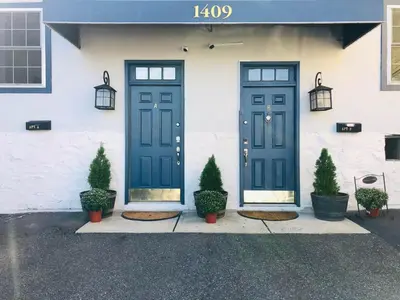 a house with two blue doors and potted plants at UPDATED Amazing Bi -Level Condo minutes from water views of New York City in North Bergen
