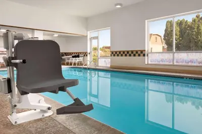 a swimming pool with a chair in front of a swimming pool at Days Inn by Wyndham Hershey in Hershey