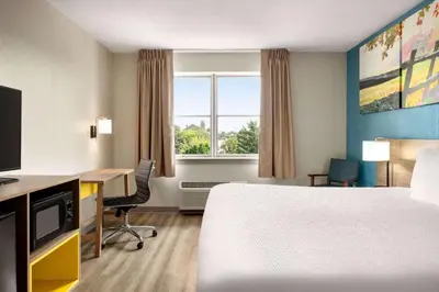 a hotel room with a bed and a desk and a window at Days Inn by Wyndham Hershey in Hershey