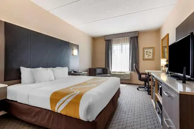 a hotel room with a large bed and a flat screen tv at Quality Inn Montgomeryville-Philadelphia in Montgomeryville