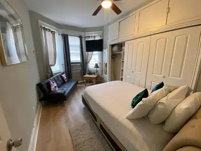 a bedroom with a bed and a chair in a room at Cozy apt in WEST NY, NEW JERSEY, at 2 bloks from bus stop-15 minutes 2NY 7MINUTES VIA NYWATERWAY FERRY-BETTER CAN'T BE!! in West New York