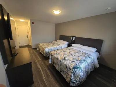 a hotel room with two beds and a hallway at Motel 6 East Windsor, NJ Hightstown in East Windsor