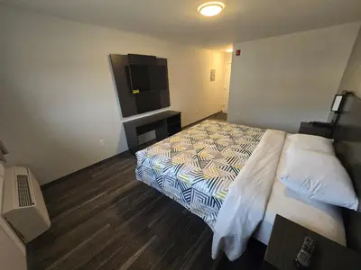a hotel room with a bed and a flat screen tv at Motel 6 East Windsor, NJ Hightstown in East Windsor