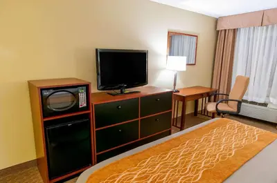 a hotel room with a bed and a tv and a room at Comfort Inn New Holland Amish Country in New Holland