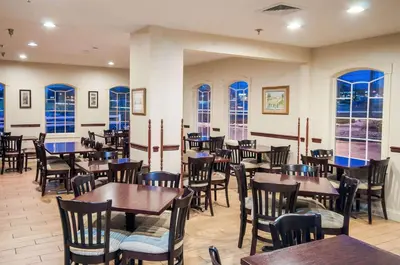 a restaurant with tables and chairs and windows at Comfort Inn New Holland Amish Country in New Holland