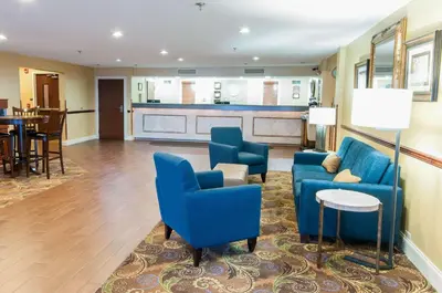 a living room with blue chairs and a table at Comfort Inn New Holland Amish Country in New Holland