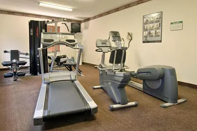 a gym with treadmills and machines in a room at Days Inn & Suites by Wyndham Cherry Hill - Philadelphia in Cherry Hill