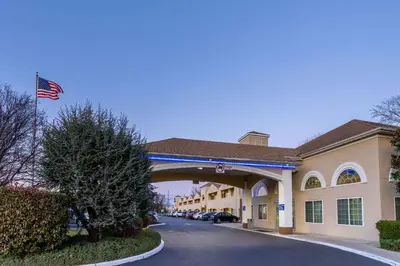 a building with an american flag and a bridge at Days Inn & Suites by Wyndham Cherry Hill - Philadelphia in Cherry Hill