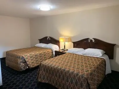 a hotel room with two beds and a lamp at Bing's Motel in Williamsport